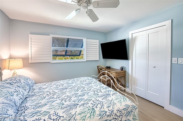 bedroom featuring a closet, a textured ceiling, ceiling fan, and wood finished floors