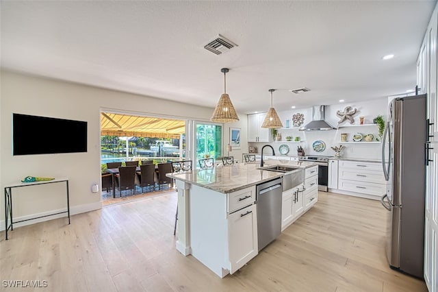 kitchen featuring open shelves, stainless steel appliances, white cabinetry, wall chimney exhaust hood, and a sink