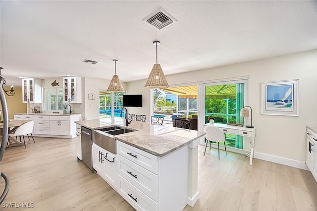 kitchen featuring a sink, visible vents, dishwasher, and light wood finished floors