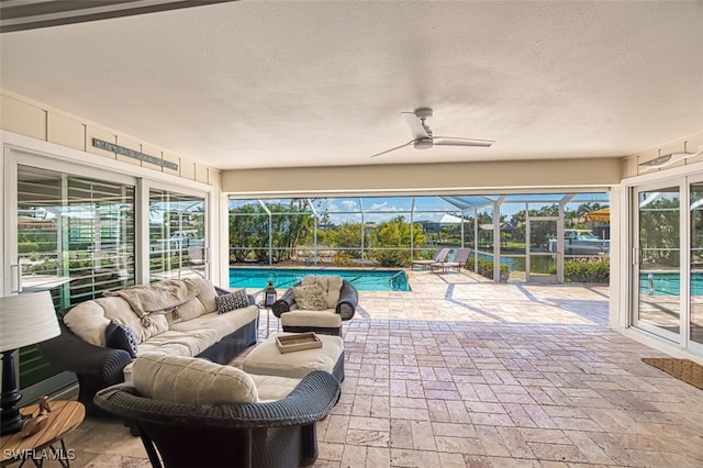 view of patio / terrace with an outdoor pool, glass enclosure, an outdoor hangout area, and a ceiling fan