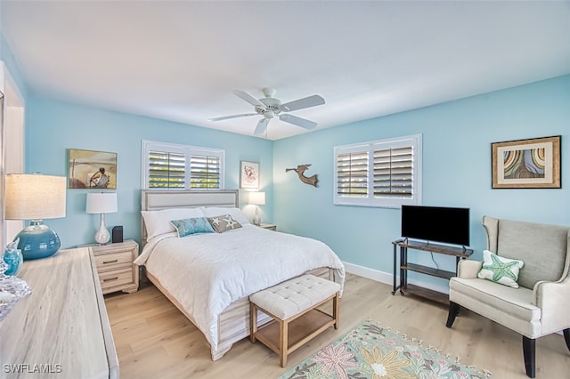 bedroom featuring baseboards, light wood-style floors, and a ceiling fan