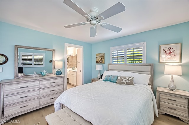 bedroom featuring ceiling fan, light wood-style flooring, and connected bathroom