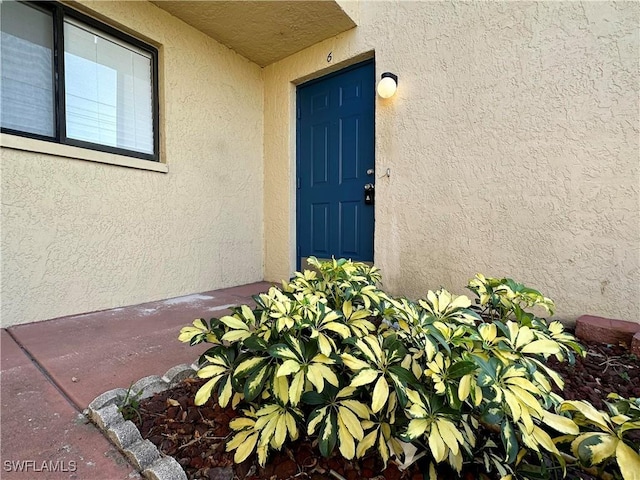 property entrance with stucco siding