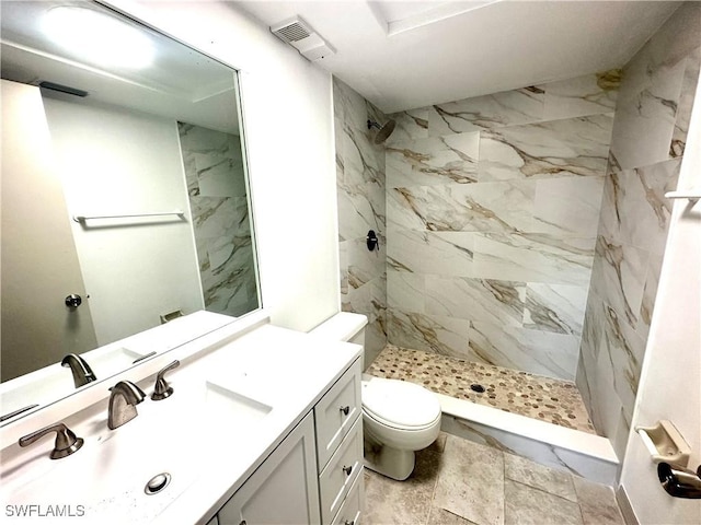 bathroom featuring toilet, a stall shower, vanity, and visible vents