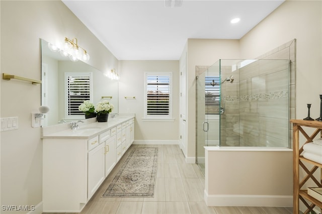 bathroom featuring a sink, a shower stall, baseboards, and double vanity