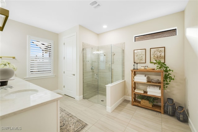 full bath featuring double vanity, visible vents, a stall shower, a sink, and baseboards