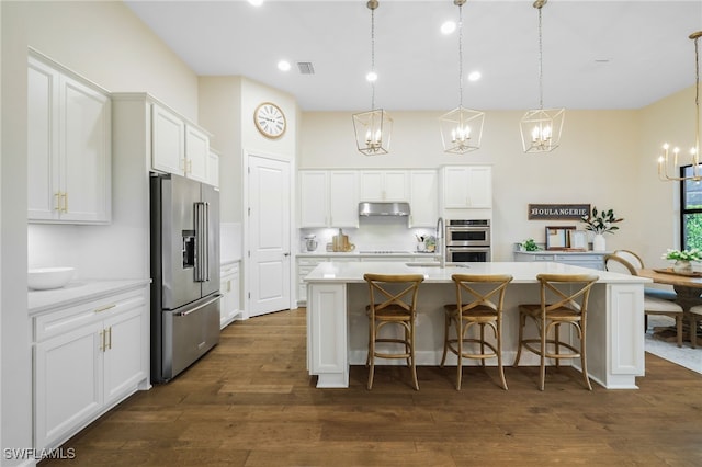 kitchen with dark wood-type flooring, visible vents, a chandelier, appliances with stainless steel finishes, and under cabinet range hood