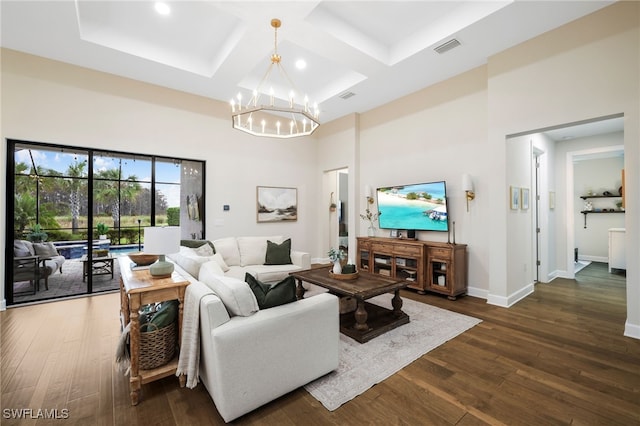 living room with baseboards, a high ceiling, visible vents, and wood finished floors