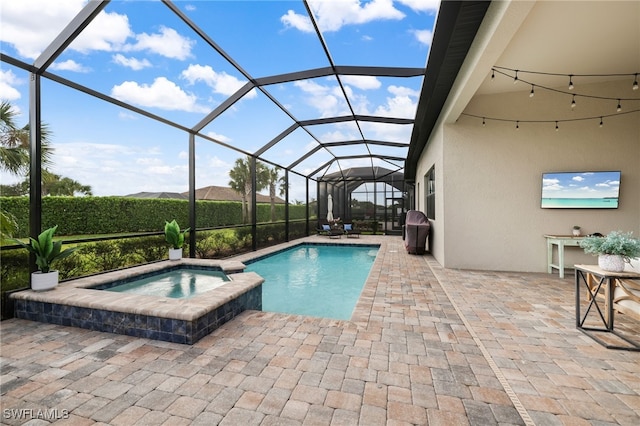 view of swimming pool with glass enclosure, a patio area, and a pool with connected hot tub