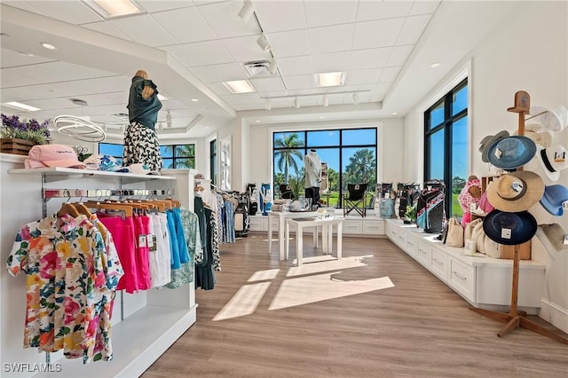 interior space featuring a tray ceiling, rail lighting, visible vents, and light wood-style floors