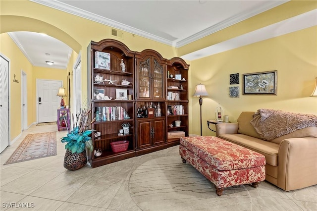 living area featuring ornamental molding, arched walkways, visible vents, and light tile patterned floors