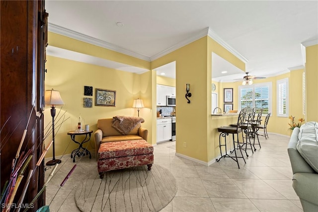 sitting room with ornamental molding, light tile patterned flooring, and baseboards