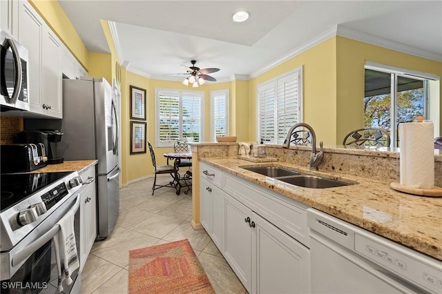 kitchen with ceiling fan, stainless steel appliances, a sink, white cabinets, and crown molding