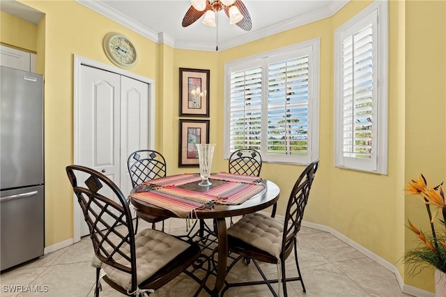 dining space with light tile patterned floors, ceiling fan, baseboards, and crown molding