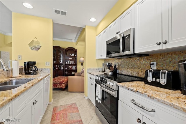 kitchen with a sink, visible vents, ornamental molding, appliances with stainless steel finishes, and tasteful backsplash