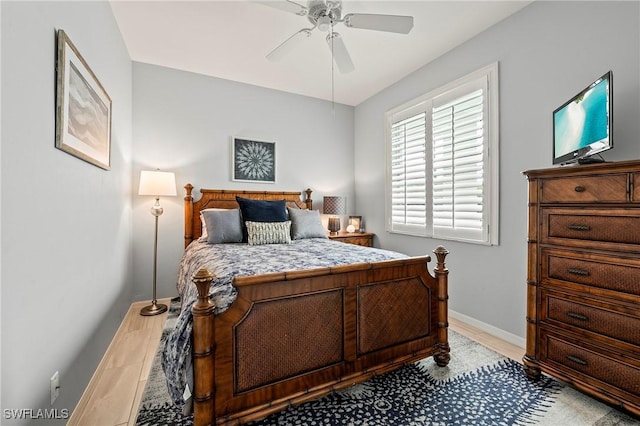 bedroom with a ceiling fan, light wood-type flooring, and baseboards