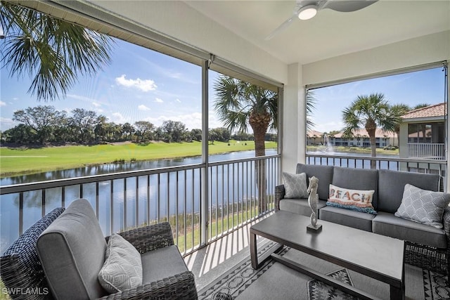 sunroom with a water view, a ceiling fan, and a healthy amount of sunlight