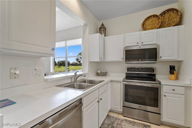 kitchen with stainless steel appliances, a sink, and white cabinets