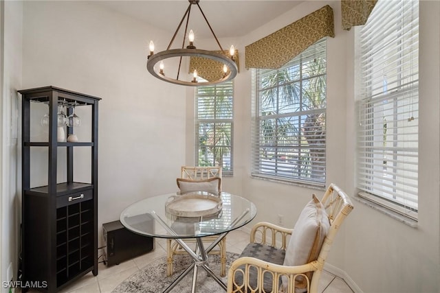 tiled dining room with a chandelier and baseboards