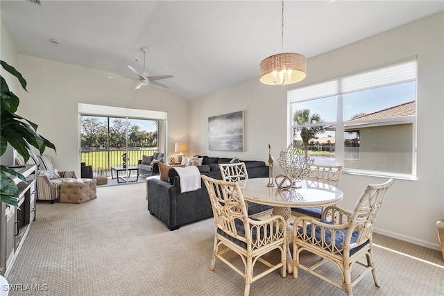 carpeted dining space with baseboards, vaulted ceiling, and a ceiling fan