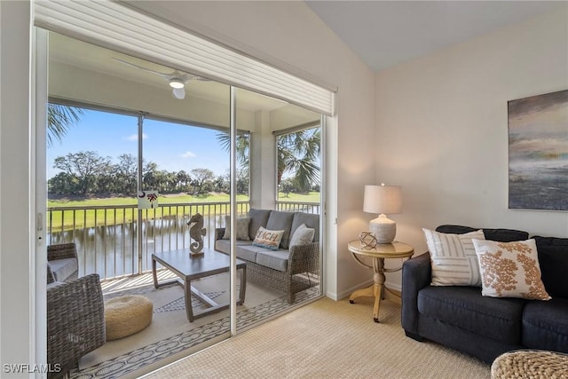 carpeted living room with a water view, vaulted ceiling, and baseboards