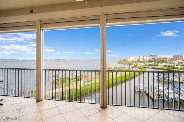 unfurnished sunroom featuring a view of city, a water view, and a wealth of natural light