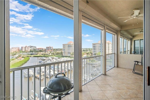 balcony featuring a ceiling fan, a city view, a water view, and grilling area