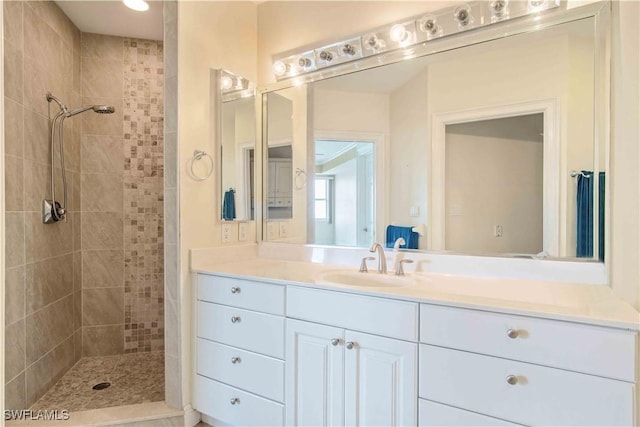 full bathroom featuring a tile shower and vanity