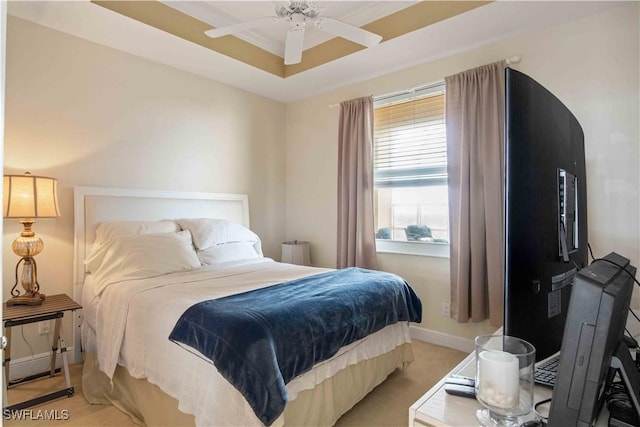 bedroom with baseboards, a raised ceiling, a ceiling fan, and light colored carpet