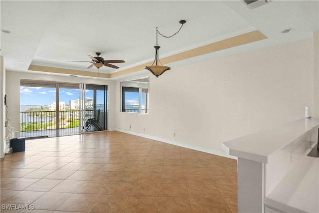 unfurnished room featuring crown molding, a raised ceiling, visible vents, ceiling fan, and baseboards