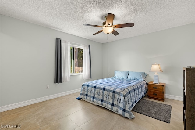 bedroom featuring a textured ceiling, ceiling fan, tile patterned floors, and baseboards