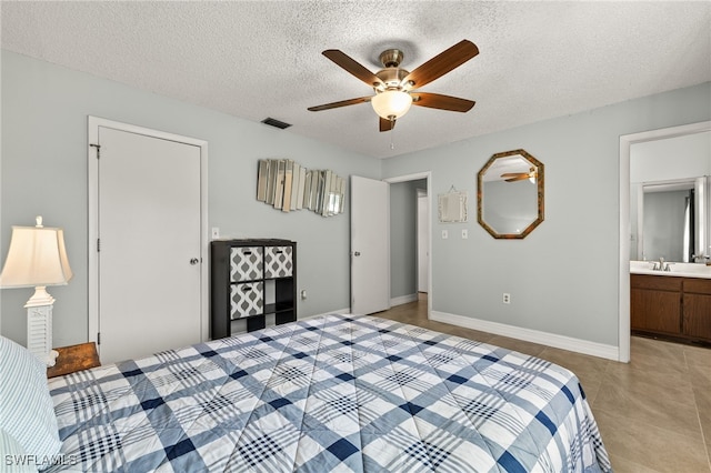 bedroom featuring a textured ceiling, ceiling fan, light tile patterned floors, a sink, and visible vents