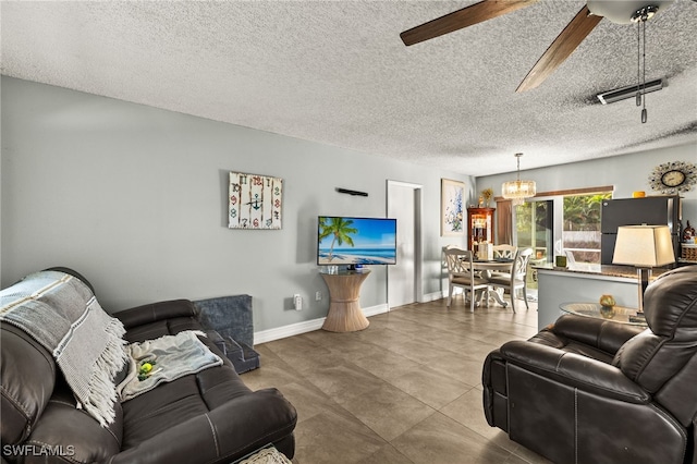 living area with baseboards, visible vents, a textured ceiling, and ceiling fan with notable chandelier