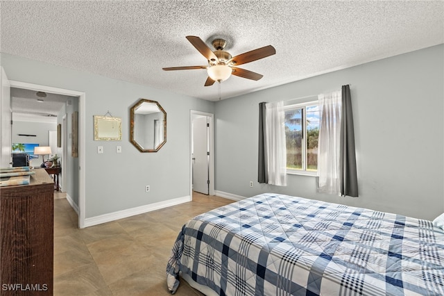 bedroom featuring a textured ceiling, a ceiling fan, and baseboards