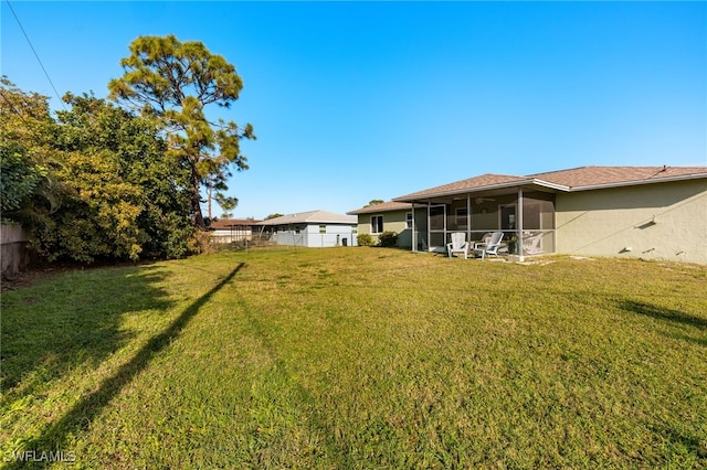 view of yard featuring a sunroom and fence