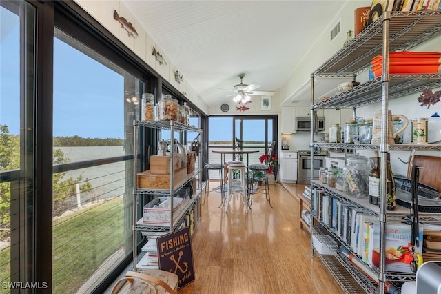 sunroom with a ceiling fan, visible vents, and vaulted ceiling