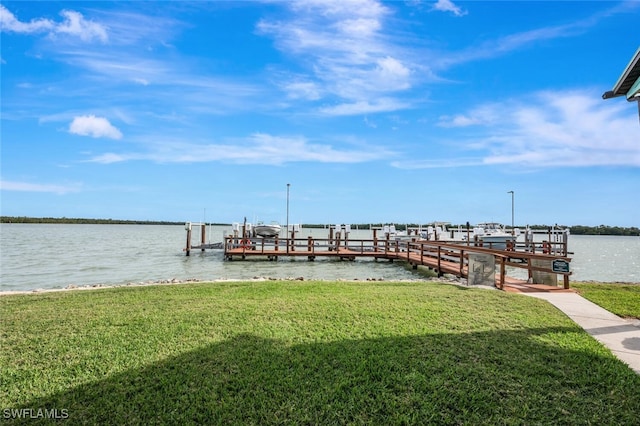 view of dock featuring a lawn, a water view, and boat lift