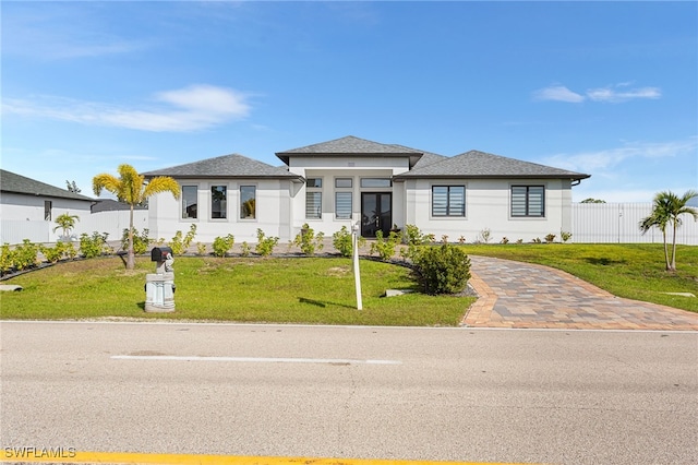 prairie-style house with a front yard and fence