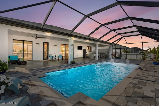 pool featuring glass enclosure, a patio, and ceiling fan