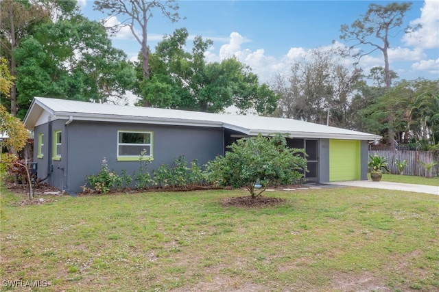 view of front of property with a garage, concrete driveway, fence, a front lawn, and stucco siding