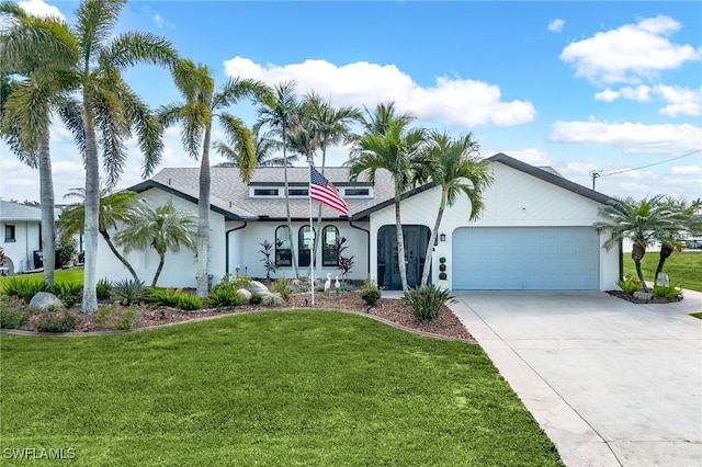 view of front of home with a garage, concrete driveway, and a front lawn