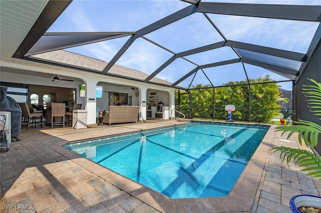 outdoor pool with ceiling fan, a patio, outdoor lounge area, and glass enclosure