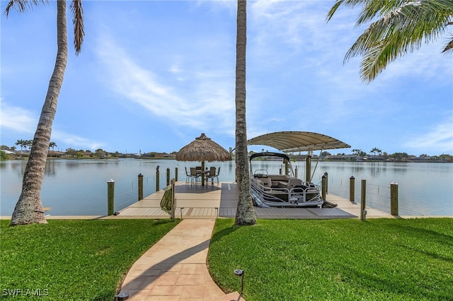 view of dock with a water view and a lawn