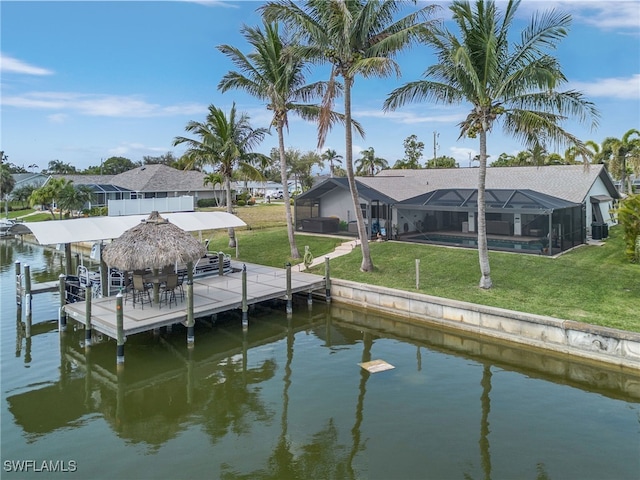 view of dock with glass enclosure, a lawn, a water view, and an outdoor pool