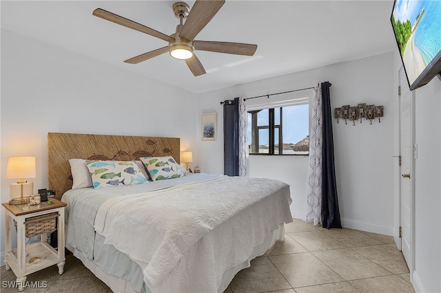 bedroom with light tile patterned flooring, a ceiling fan, and baseboards