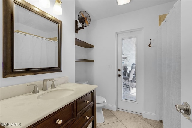 bathroom featuring tile patterned flooring, baseboards, vanity, and toilet