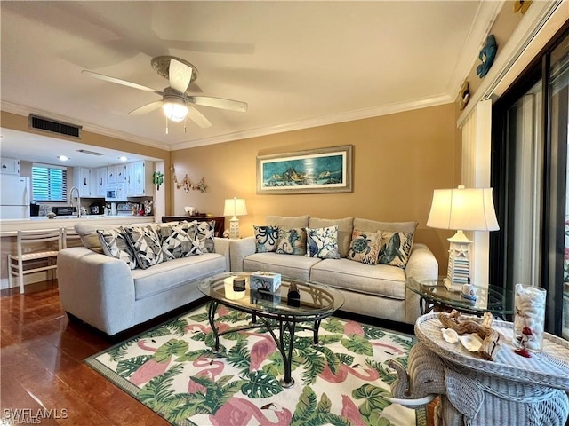 living area featuring ceiling fan, dark wood-type flooring, visible vents, and crown molding