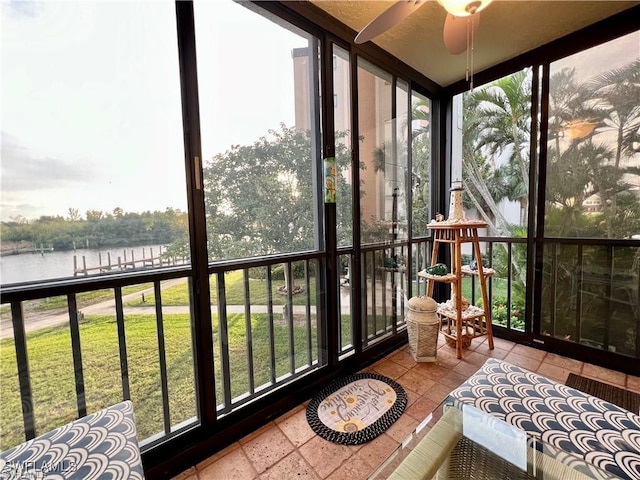 sunroom featuring a water view