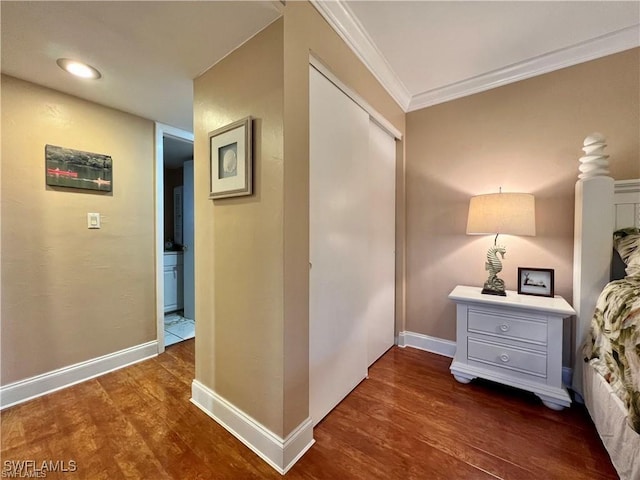 hall featuring ornamental molding, dark wood-type flooring, and baseboards