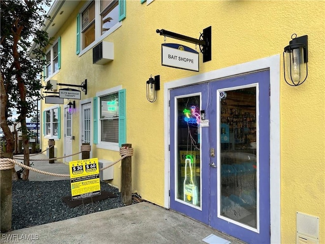 property entrance with visible vents and stucco siding